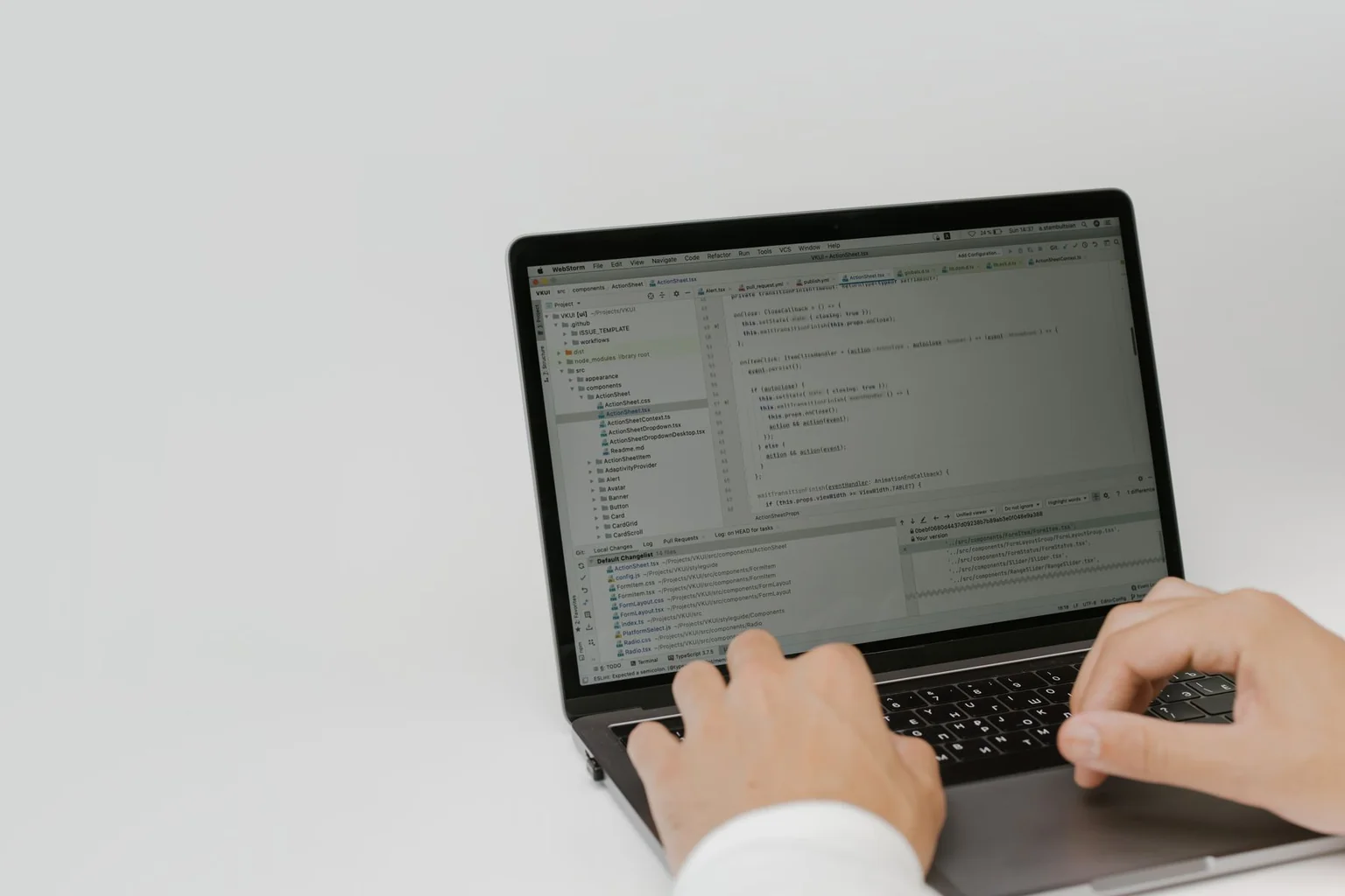 Hands typing in a code editor on a laptop.