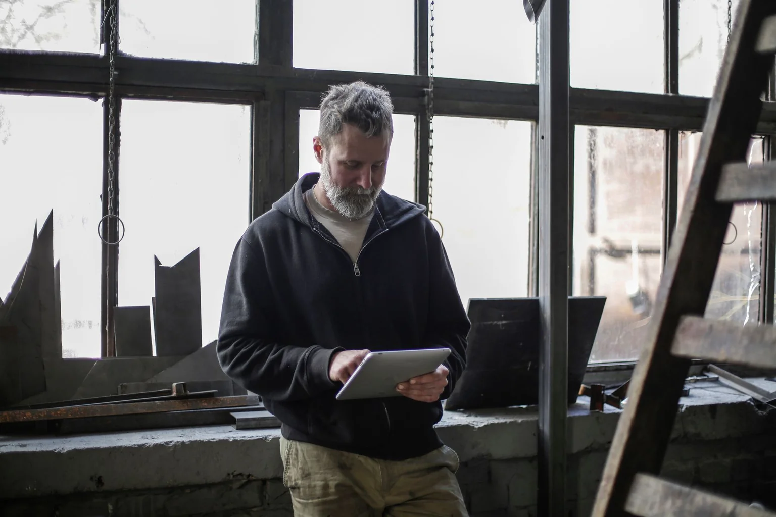 A service technician using a tablet to manage technical work in a workshop.